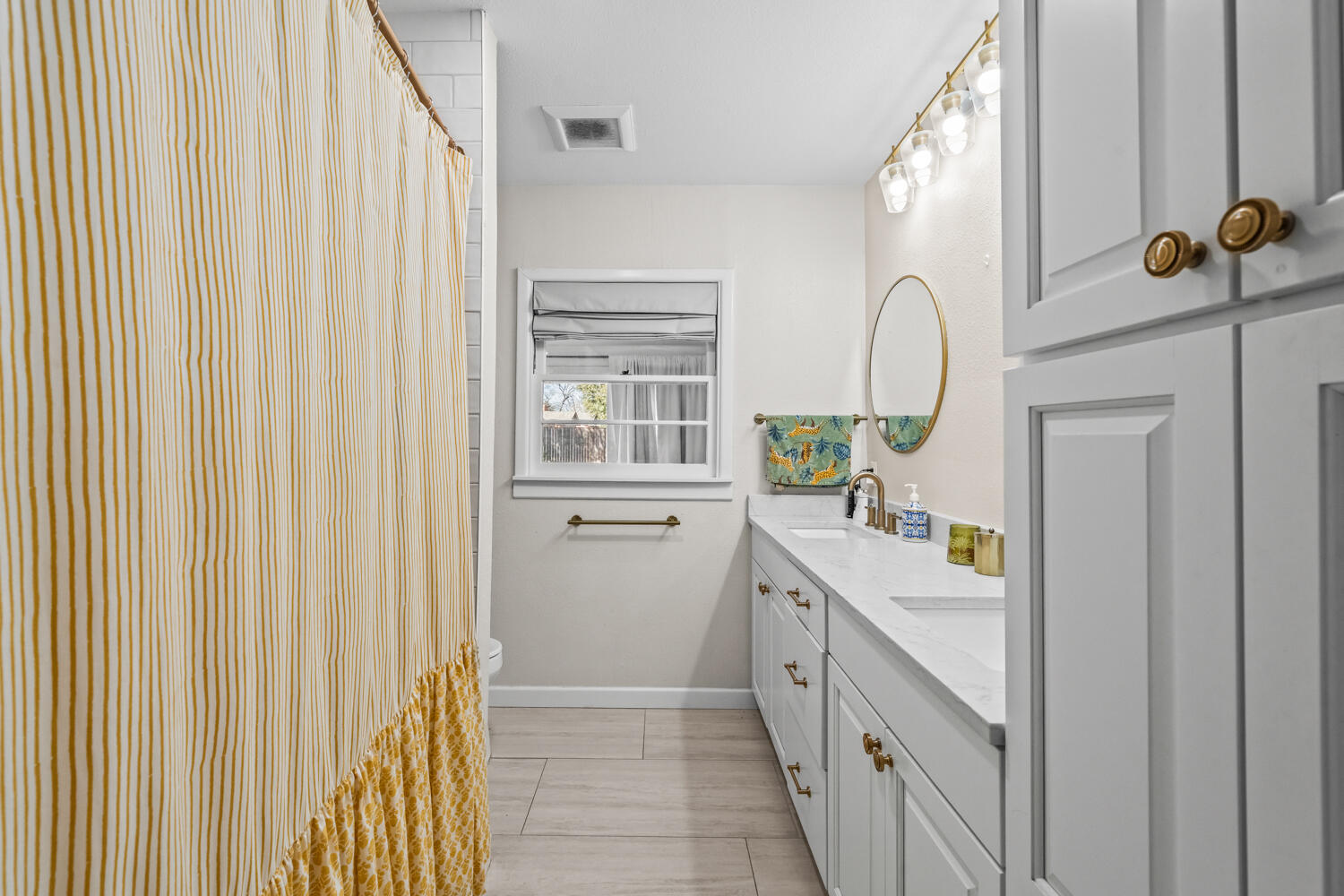 3310 24th Street Lubbock, TX 79410 - Photo 31 of 65 a bathroom with a double vanity sink and a mirror