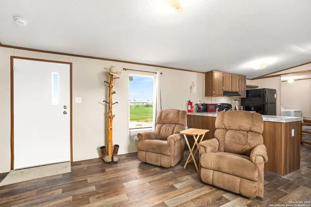 a living room with furniture and a view of kitchen