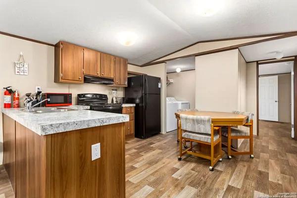a kitchen with granite countertop kitchen island wooden cabinets and stainless steel appliances