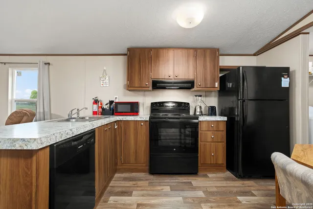 a kitchen with stainless steel appliances granite countertop a refrigerator stove and sink