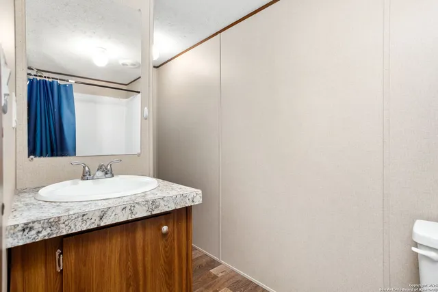 a bathroom with a granite countertop sink and a mirror