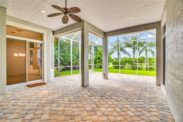 a view of a room with window a ceiling fan and front door
