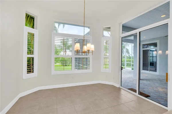 a view of an empty room with glass door and windows