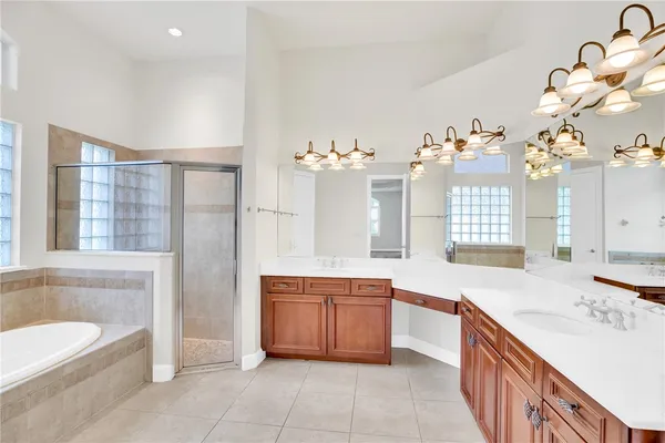 a spacious bathroom with a tub sink and mirror