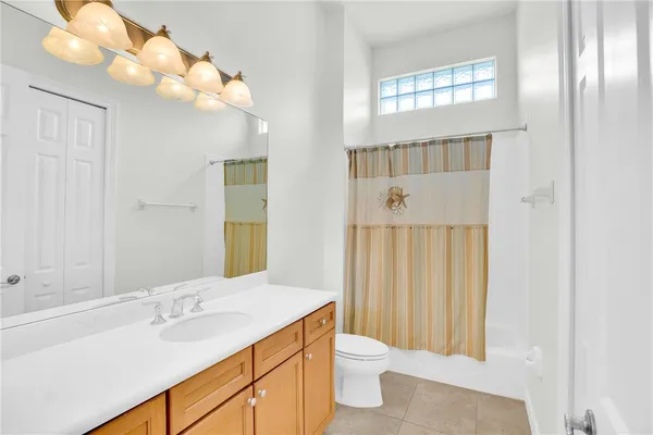 a bathroom with a sink vanity granite and toilet