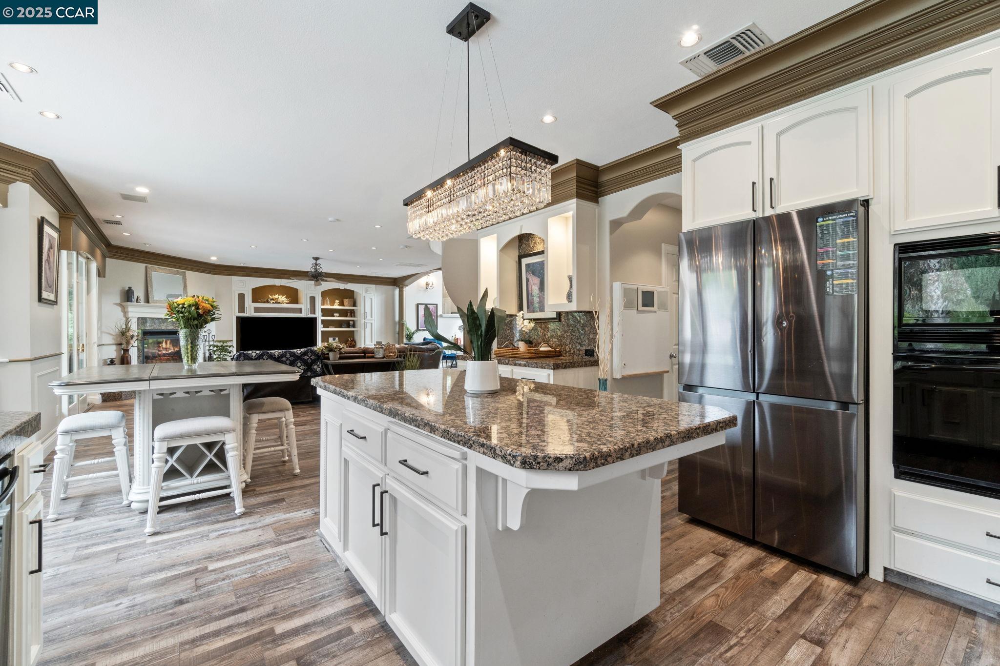 2550 East Jenny Avenue Fresno, CA 93720 - Photo 18 of 49 a kitchen with stainless steel appliances granite countertop a kitchen island a stove a refrigerator and a sink