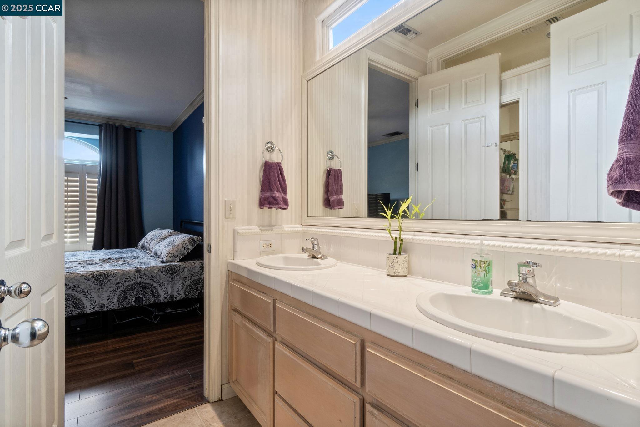 2550 East Jenny Avenue Fresno, CA 93720 - Photo 35 of 49 a en suite bathroom with a double vanity sink and mirror