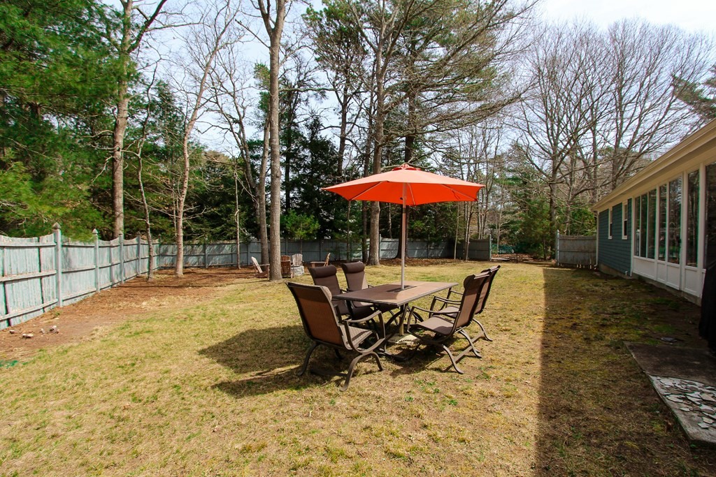 47 Foxglove Road Barnstable, MA 02632 - Photo 26 of 33 a view of a patio with a table and chairs under an umbrella