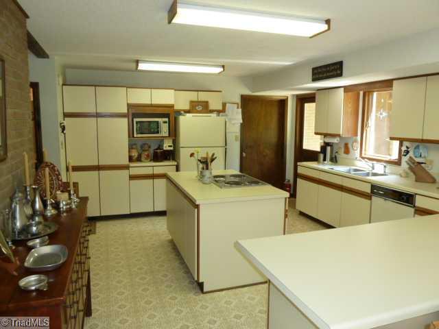 1195 Daisy Trail Road Germanton, NC 27019 - Photo 7 of 16 Kitchen. Spacious kitchen with island and lots of cabinets. Large laundry room off the kitchen with utility sink & shower, washer & dryer remain.