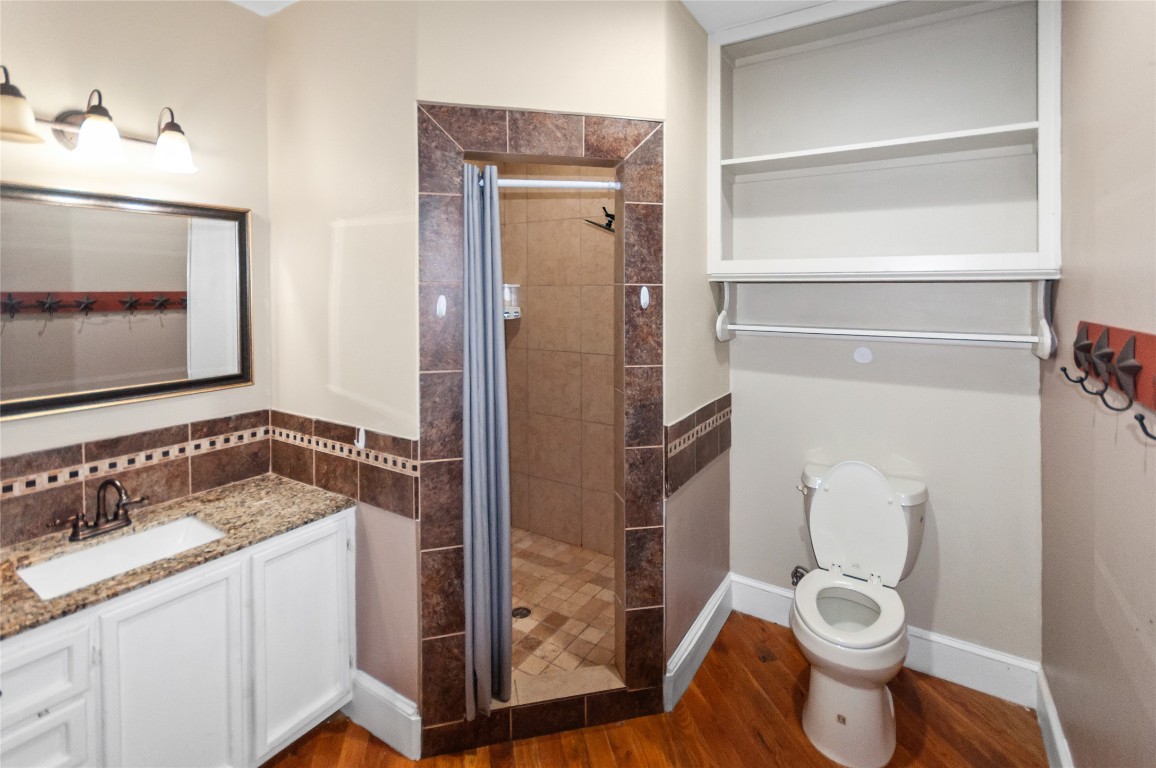 6588 Starks Road Mason, TX 76856 - Photo 23 of 40 a bathroom with a granite countertop toilet sink and mirror