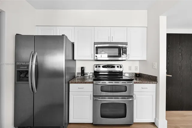 a kitchen with stainless steel appliances a stove a refrigerator and a microwave
