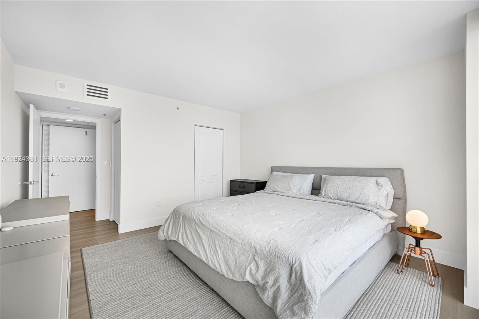 90 Alton Road, Unit 1908 Miami Beach, FL 33139 - Photo 19 of 57 a bedroom with a bed and wooden floor