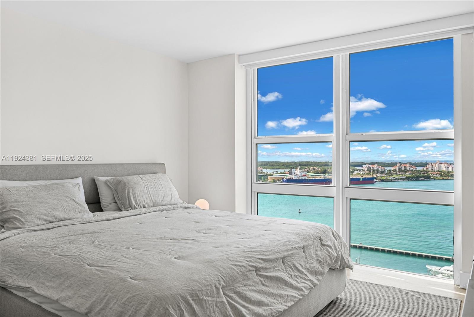 90 Alton Road, Unit 1908 Miami Beach, FL 33139 - Photo 21 of 57 a bedroom with a bed and large window