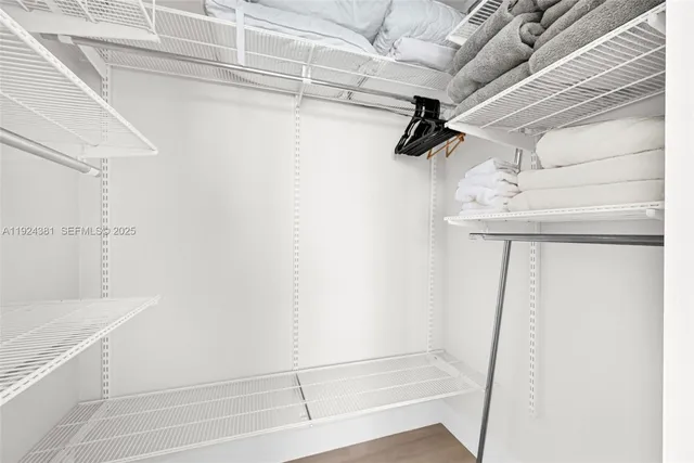 a view of walk in closet with empty racks