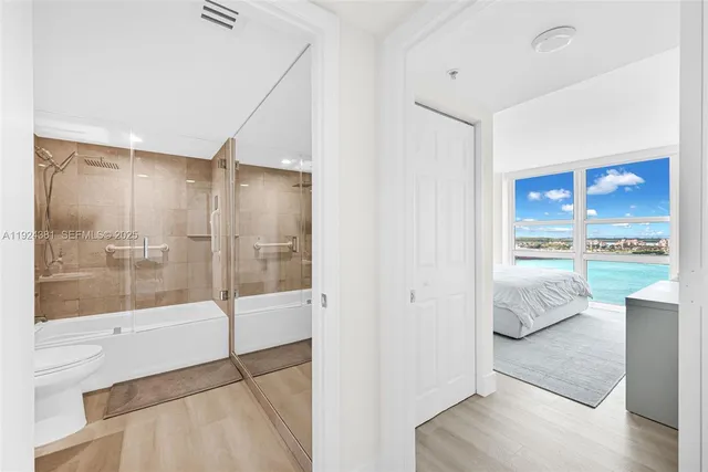 a bathroom with a bathtub shower sink mirror and toilet