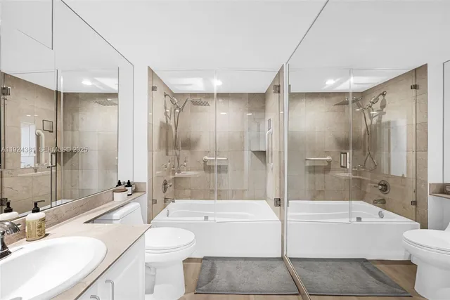 a bathroom with a sink a toilet a mirror and bathtub