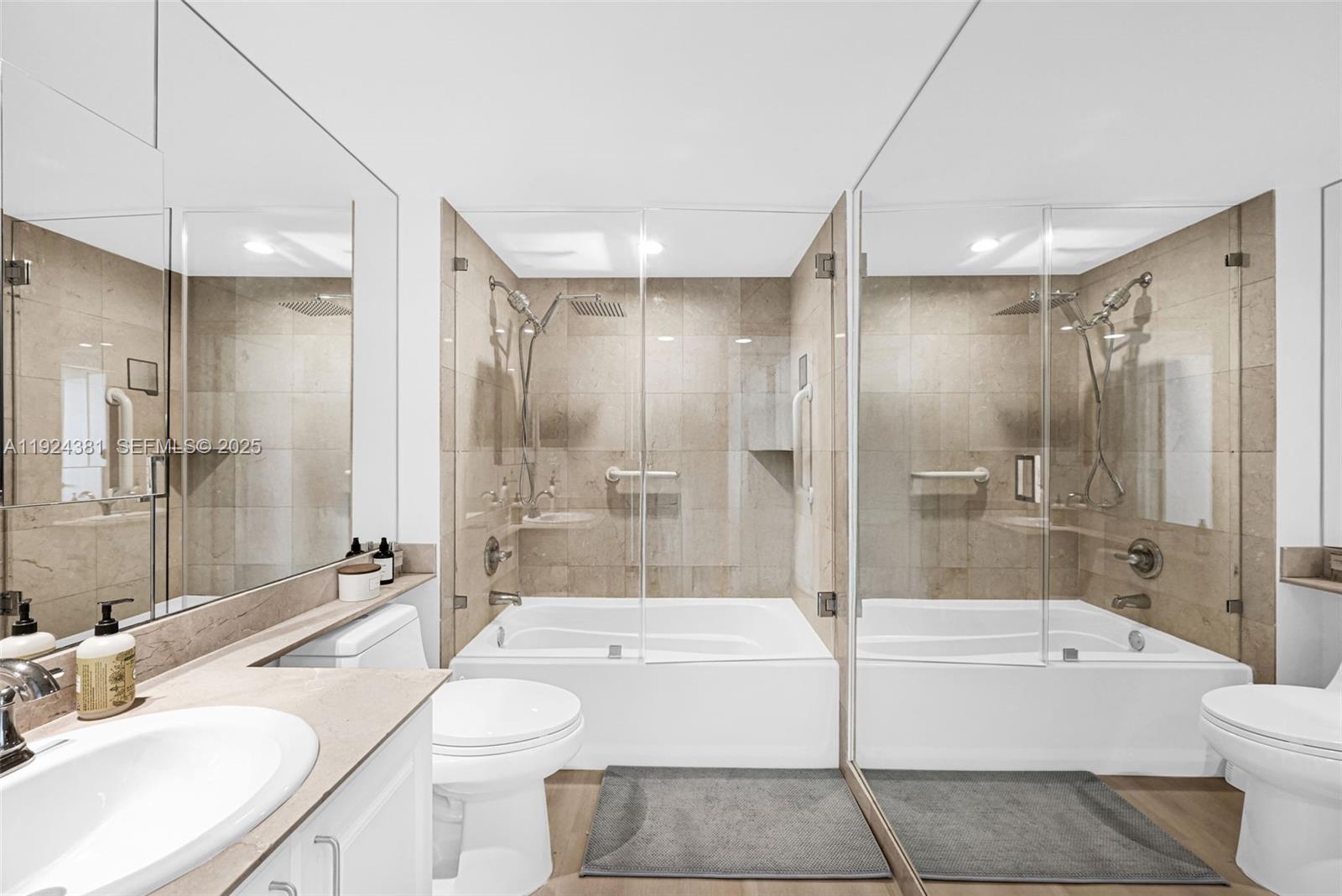 90 Alton Road, Unit 1908 Miami Beach, FL 33139 - Photo 26 of 57 a bathroom with a bathtub shower sink mirror and toilet