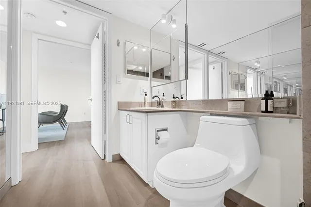 a large white kitchen with white cabinets and stainless steel appliances