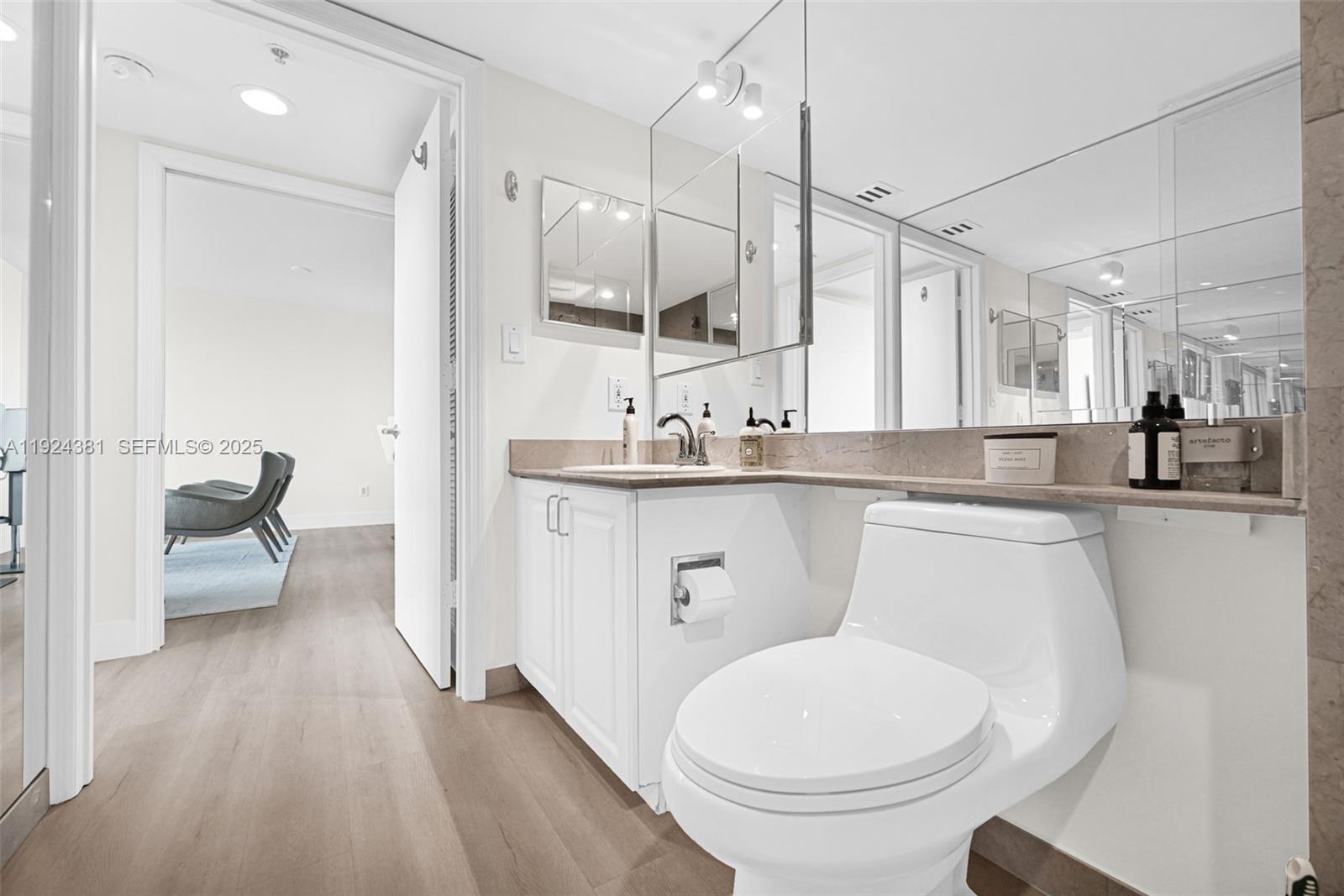 90 Alton Road, Unit 1908 Miami Beach, FL 33139 - Photo 28 of 57 a bathroom with a toilet a sink and a mirror