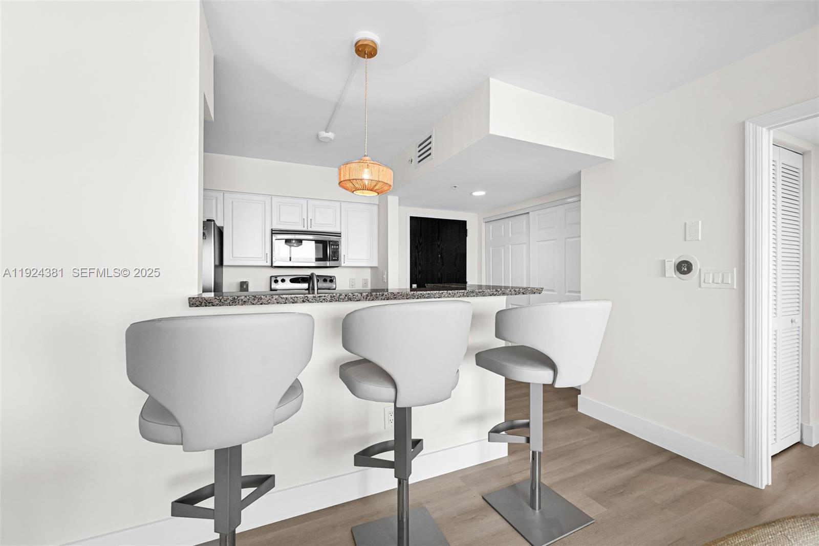 90 Alton Road, Unit 1908 Miami Beach, FL 33139 - Photo 7 of 57 a living room with a table chairs and a kitchen view