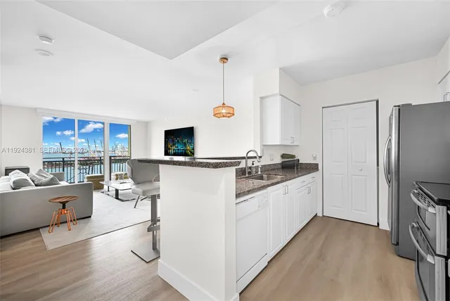 a kitchen with stainless steel appliances granite countertop a refrigerator and a stove top oven