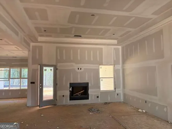 a view of an empty room with a fireplace and a window