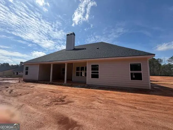 a front view of a house with yard and trees