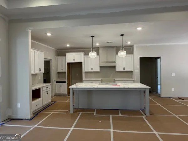 a view of a kitchen with kitchen island a sink a stove and a refrigerator