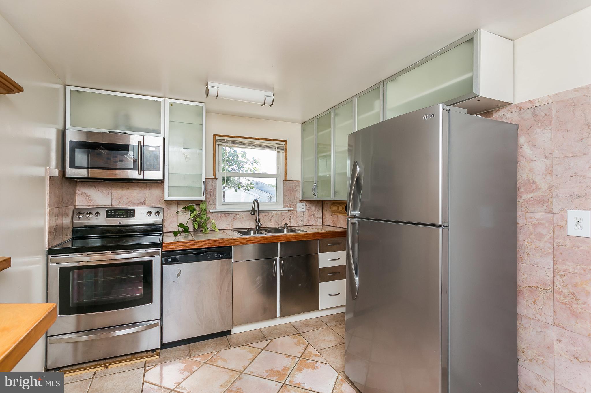 4812 Galley Road Baltimore, MD 21236 - Photo 11 of 30 a kitchen with stainless steel appliances a refrigerator stove and microwave
