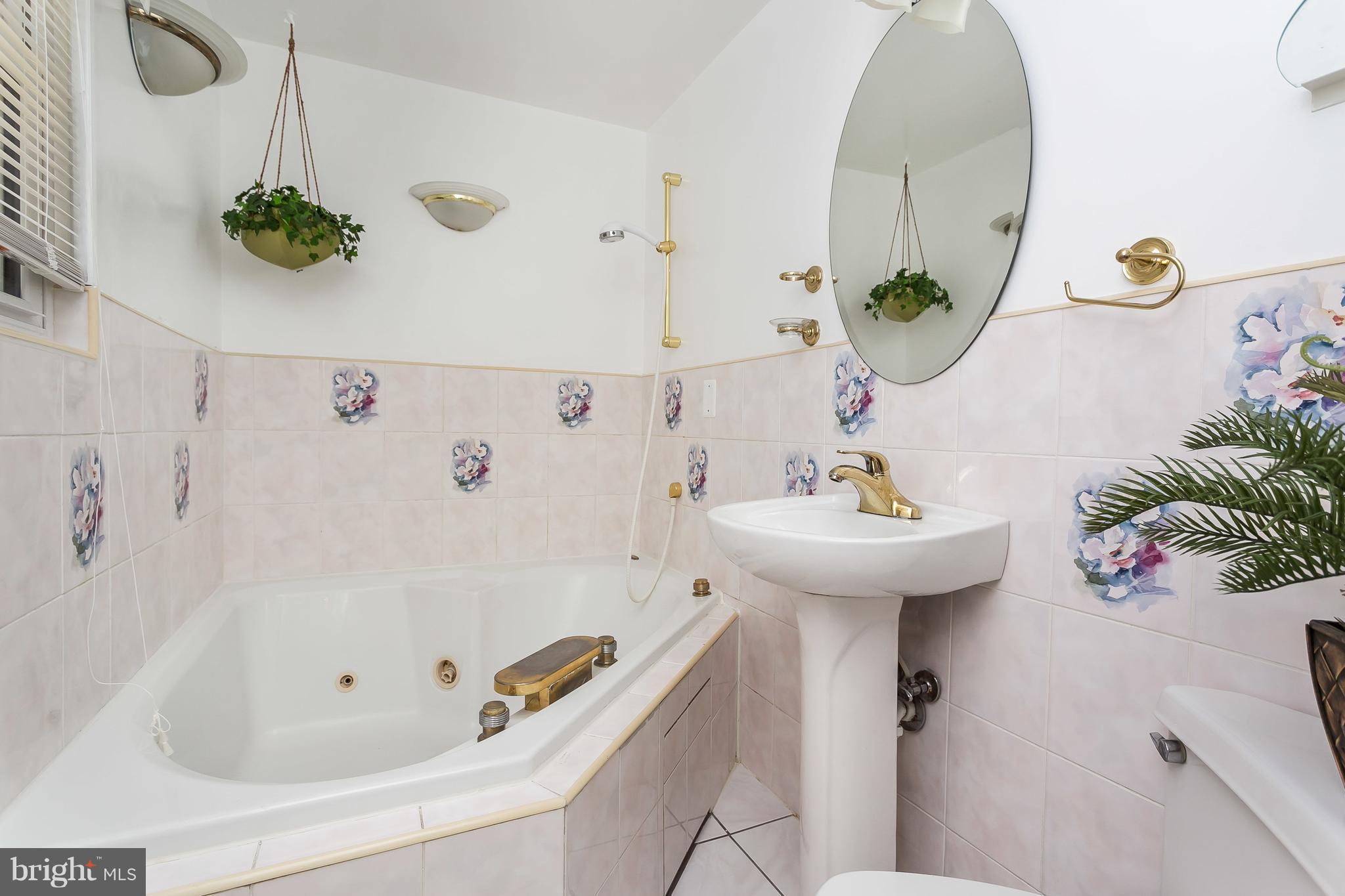 4812 Galley Road Baltimore, MD 21236 - Photo 22 of 30 a bathroom with a sink and mirror with bathtub