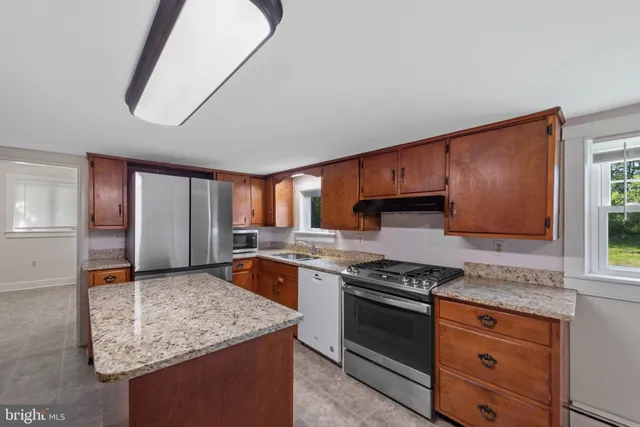 a kitchen with stainless steel appliances granite countertop a stove sink and cabinets
