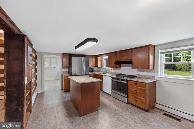 a kitchen with stainless steel appliances granite countertop a stove top oven a sink dishwasher a refrigerator and a stove