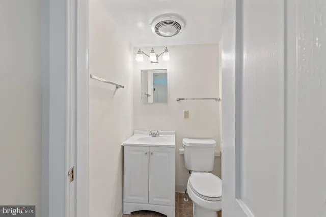a bathroom with a toilet a sink and mirror