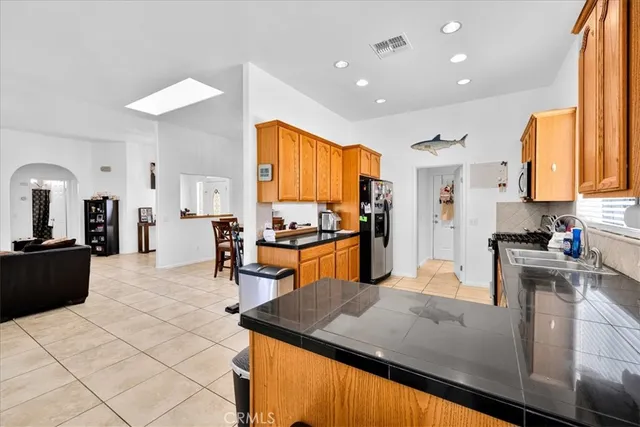 a living room with furniture kitchen view and a wooden floor