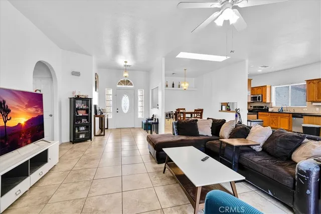 a living room with furniture a flat screen tv and floor to ceiling window
