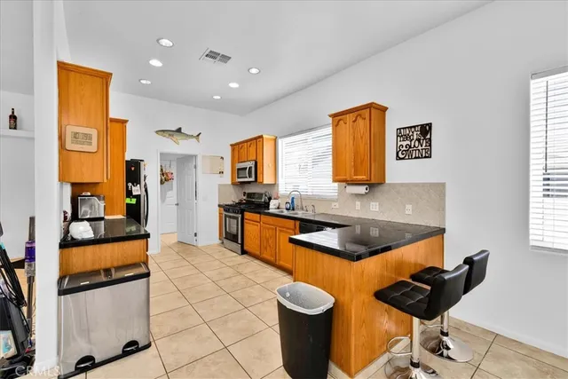 a kitchen with stainless steel appliances granite countertop sink stove and refrigerator
