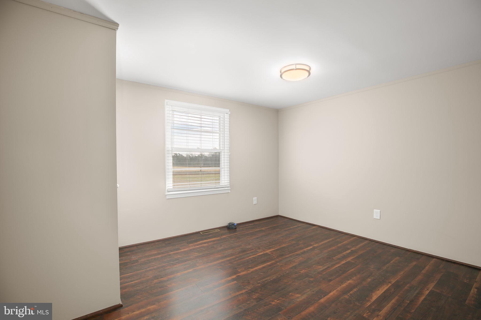 92 McCarty Road Fredericksburg, VA 22405 - Photo 20 of 39 an empty room with wooden floor and windows