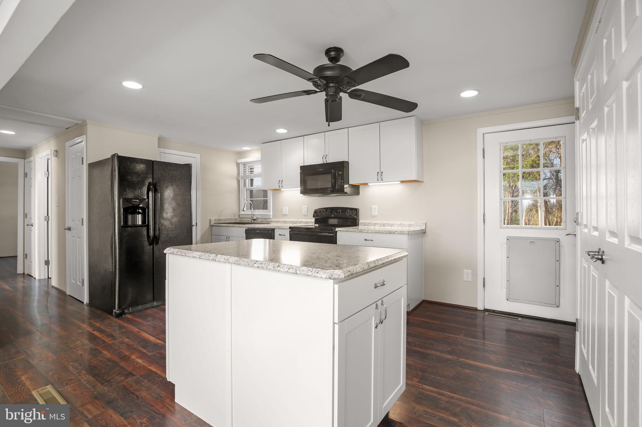 92 McCarty Road Fredericksburg, VA 22405 - Photo 5 of 31 a kitchen with stainless steel appliances kitchen island granite countertop a refrigerator a sink a stove and a wooden floors