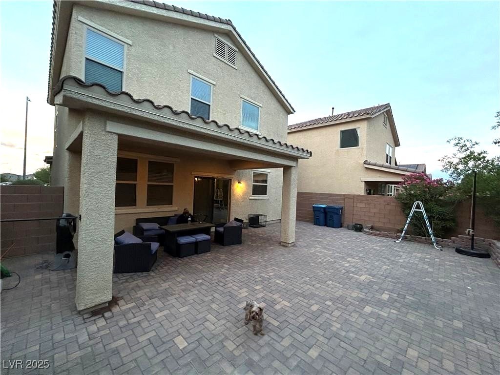 8977 Melridge Road Las Vegas, NV 89148 - Photo 6 of 35 Rear view of property with a tile roof, a patio area, fence, an outdoor hangout area, and stucco siding