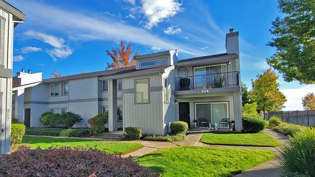 a view of a house with a yard and potted plants