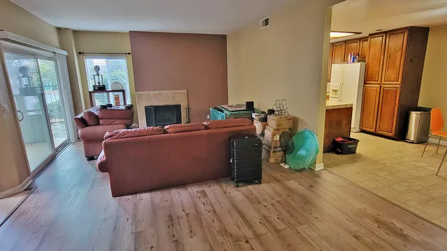 a living room with furniture a fireplace and a wooden floor