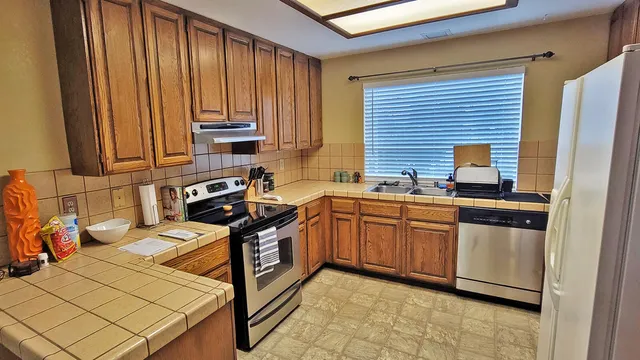 a kitchen with stainless steel appliances granite countertop a stove a sink and a microwave