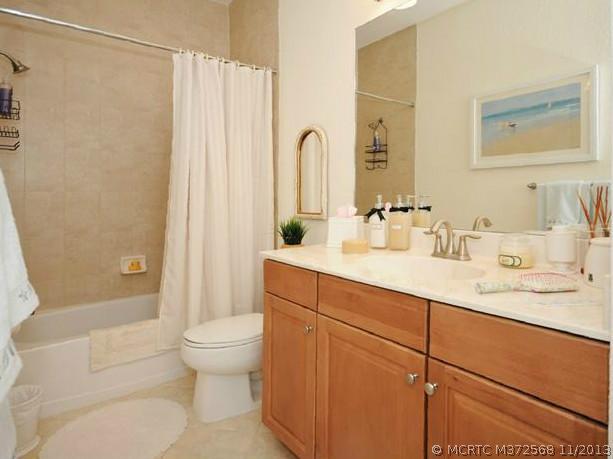134 Southwest Walking Path Stuart, FL 34997 - Photo 17 of 25 Other. Guest Bath with maple cabinetry, brushed nickel faucets, tile up to the ceiling, shower/tub combination, tile flooring