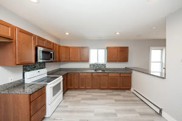 a kitchen with stainless steel appliances granite countertop a stove top oven a sink and dishwasher