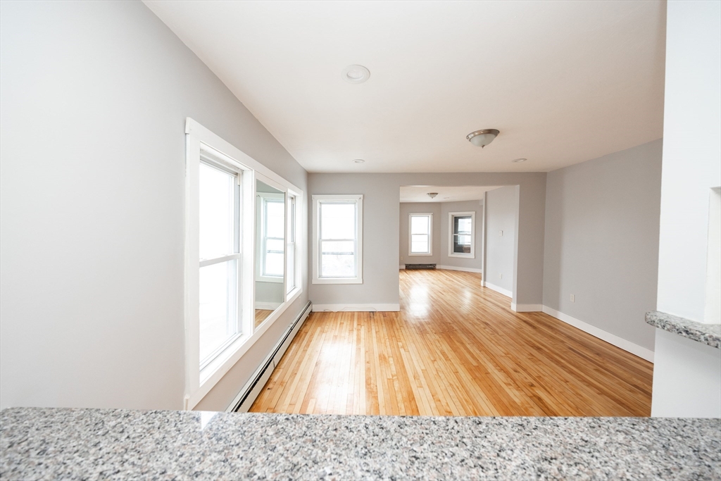 10 Alpine Street, Unit 1 Worcester, MA 01610 - Photo 8 of 14 a view of an empty room with wooden floor and a window