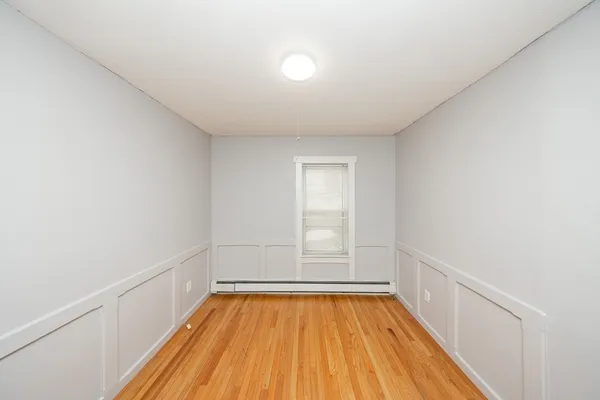 a view of room with window and wooden floor