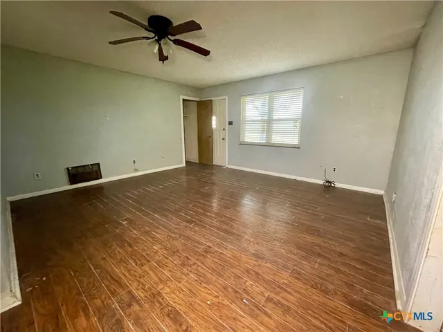 wooden floor in an empty room with a window