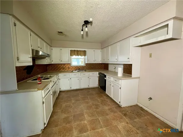 a kitchen with a sink window and cabinets