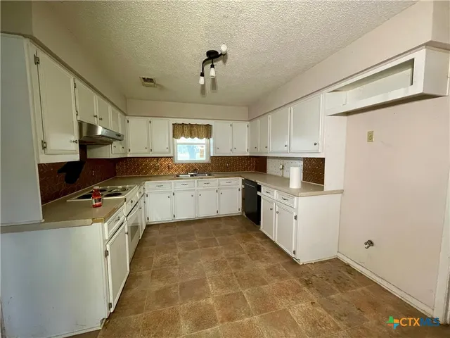 a kitchen with a sink window and cabinets