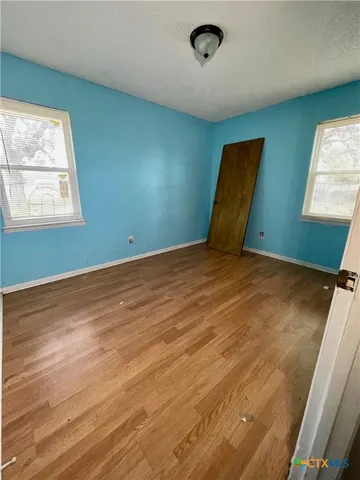 a view of a room with wooden floor and windows